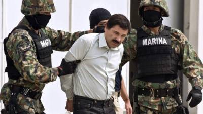 (FILES) In this file photo taken on February 22, 2014 Mexican drug trafficker Joaquin Guzman Loera aka 'el Chapo Guzman' (C), is escorted by marines as he is presented to the press in Mexico City. - After a dramatic decades-long run as one of the world's most notorious druglords, there is little suspense about what will happen in a New York courtroom on Wednesday: Joaquin 'El Chapo' Guzman is expected to be sentenced to life in prison. (Photo by Ronaldo SCHEMIDT / AFP)