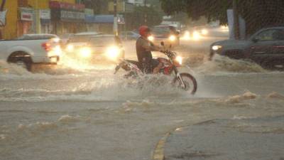 Un motociclista transita por una avenida inundada tras el paso del ciclón Lorena en la ciudad de Culiacán, el estado de Sinaloa. Foto: EFE