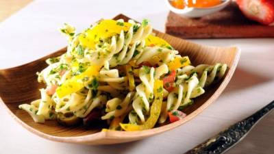 Picar finamente las hierbas para preparar la ensalada con pasta.