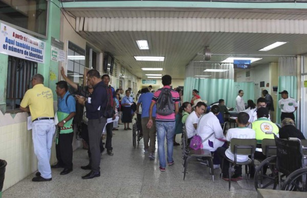 A man allegedly infected with the new coornaviurs is helped by his daughter at a field hospital set up in the yard of the School Hospital in Tegucigalpa, on July 1, 2020. - Honduras is overwhelmed by deaths caused by COVID-19 and the large number of people infected that are admitted every day in different hospitals across the country. (Photo by ORLANDO SIERRA / AFP)