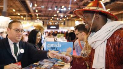 Un expositor de Mali solicita información de Granada en el stand andaluz de la Fitur en Madrid. Foto: Efe