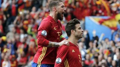 Gerard Piqué, con mirada desafiante, celebra su gol con Sergio Ramos en sus hombros. Foto EFE