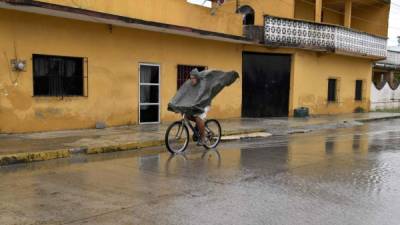 Un hombre circula bajo la lluvia por las calles de Tecolutla, en el estado mexicano de Veracruz.