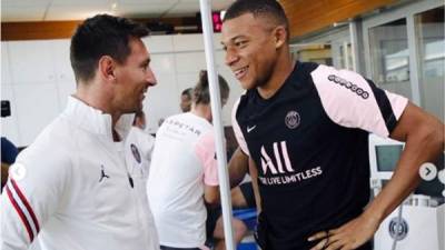 Kylian Mbappé saludando con una sonrisa a Lionel Messi.