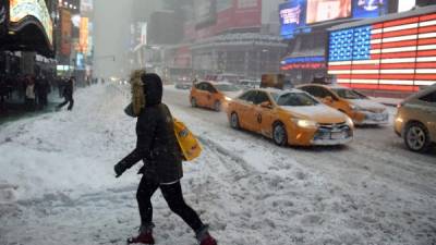 NEW YORK, NY - JANUARY 23: Pedestrians cope with snow covering sidewalks and streets in Time Square on January 23, 2016 in New York City. A major Nor'easter is hitting much of the East Coast and parts of the South as forecasts warn of up to two feet of snow in some areas. Astrid Riecken/Getty Images/AFP== FOR NEWSPAPERS, INTERNET, TELCOS & TELEVISION USE ONLY ==
