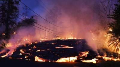 PAHOA, HI - MAY 27: Lava from a Kilauea volcano fissure advances up a residential street in Leilani Estates, on Hawaii's Big Island, on May 27, 2018 in Pahoa, Hawaii. Lava from the volcano also flowed to a geothermal power plant today raising fears that toxic gas could be released if wells are breached by lava. The Big Island, one of eight main islands that make up Hawaii state, is struggling with tourist bookings following the Kilauea volcano eruptions, with summer bookings at the island down 50 percent. Officials stress that the eruptions have thus far only affected a small portion of the island. Mario Tama/Getty Images/AFP== FOR NEWSPAPERS, INTERNET, TELCOS & TELEVISION USE ONLY ==