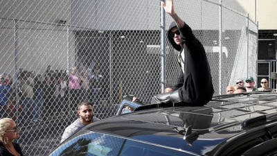 Justin Bieber saluda al público de forma irónica tras salir de prisión hoy en Miami, Estados Unidos.