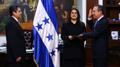 El presidente de Honduras, Juan Orlando Hernández, toma juramento al nuevo embajador en Estados Unidos, Marlon Tábora. Observa la canciller María Dolores Agüero.