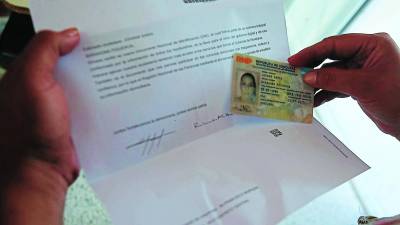 Una hondureña verifica su DNI tras reclamarla en el Registro.