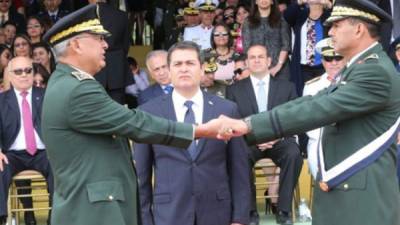 El presidente Juan Orlando Hernández observa el traspaso de mando de las Fuerzas Armada entre el entrante general Francisco Isaías Álvarez -izquierda- y el saliente general Fredy Díaz -derecha-.