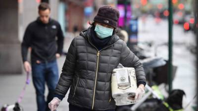 Una personas se protege con una mascarilla para evitar el contagio del coronavirus. Foto: AFP