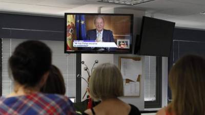 Trabajadores de la Agencia EFE escuchan el mensaje del Rey Don Juan Carlos, a través de la radio y la televisión, con el que se ha dirigido a los españoles para dar a conocer los motivos de su abdicación. EFE/Maialen