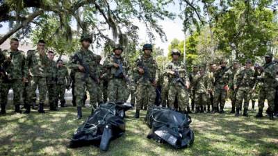 Miembros del ejército colombiano posan ante los cadáveres de dos combatientes de las FARC.