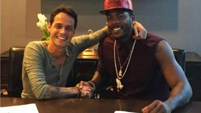 Marc Anthony con el lanzador cubano Aroldis Chapman, su primera figura en la empresa.