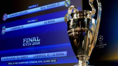 El trofeo de la Champions League expuesto junto a una pantalla con los emparejamientos tras el sorteo de semifinales. Foto EFE