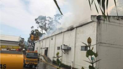 El momento cuando personal del Cuerpo de Bomberos trata de apagar el incendio en en una de las bodegas de Zip Choloma #1.