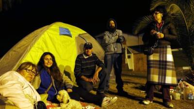 Una familia se prepara para pasar la noche al aire libre en una tienda de campaña en un parque de Iquique hoy, miércoles 2 de abril de 2014, en el norte del país.