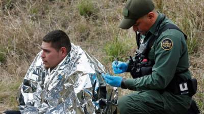 Un agente de la Patrulla Fronteriza revisa médicamente a un hombre que intentó cruzar el Río Grande para ingresar ilegalmente a EEUU. EFE/Archivo