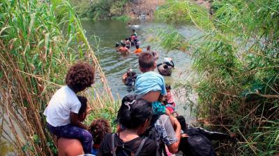 <b><span class=mln_uppercase_mln>Riesgo.</span></b> Migrantes durante la ruta migratoria a través de un río.
