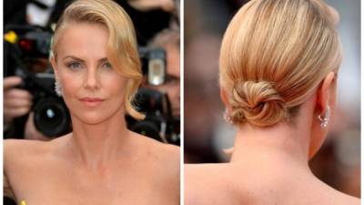 La actriz Charlize Theron con maquillaje monocromático, cabello ondulado y la melena recogida.