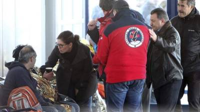Miembros de los servicios de rescate conversan con los siete pasajeros del ferri 'Norman Atlantic' trasladados en helicóptero al aeropuerto de Corfu en Grecia. EFE