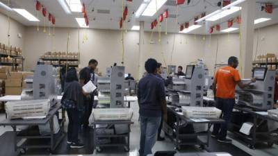 El trabajador electoral introdujo las boletas en las máquinas de tabulación en la oficina del Supervisor de Elecciones del Condado de Broward para iniciar el conteo.