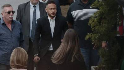 Neymar (C) llegó en muletas al Recinto de Defensa de las Mujeres en Sao Paulo, Brasil.