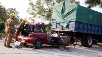 El turismo rojo quedó destruido al impactar en la parte trasera de un camión cargado de bananos verdes. Dos de los ocupantes del carro murieron por el fuerte choque.
