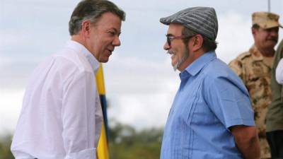Londoño (der.) junto al presidente colombiano, Juan Manuel Santos, son los artífices del histórico desarme del grupo guerrillero.