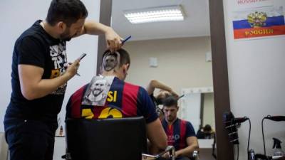 Ahora cientos de hinchas van a las peluquerías para realizarse cortes con el rostro de Lionel Messi. FOTO AFP.