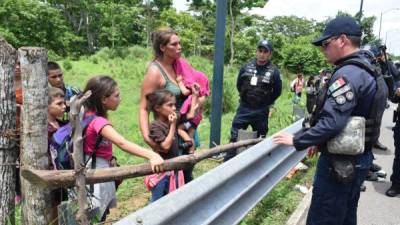 Policías intentan persuadir a una familia de migrantes centroamericanos que viajaba en caravana que fue interceptada para evitar que continuara su trayecto por territorio mexicano. Foto de archivo EFE.