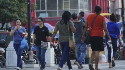 Personas caminando por el parque central de San Pedro Sula. Foto: Amílcar Izaguirre.