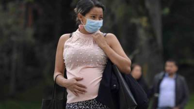 Una mujer embarazada usa una mascarilla para protegerse del Covid-19. AFP