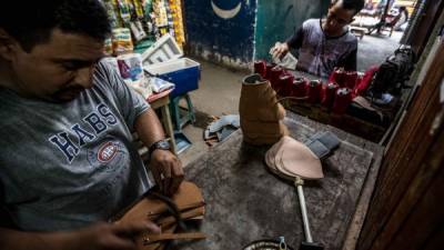 Dos hombres trabajan en una zapatería. Foto: Yoseph Amaya.