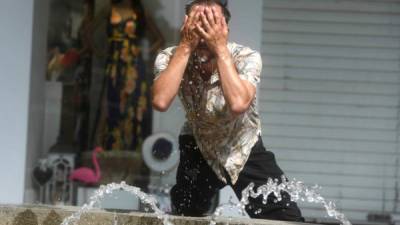 Un hombre intenta refrescarse en una fuente de Córdoba, en una jornada marcada por la ola de calor que afecta a toda la Península. EFE