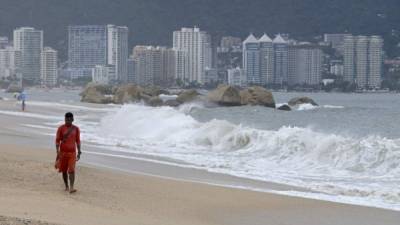 Un socorrista camina en una playa de Acapulpo. AFP