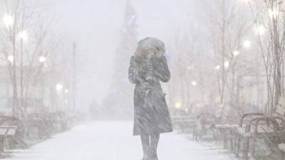 Una mujer camina por la calle durante una tormenta de nieve en Rusia. EFE/Archivo