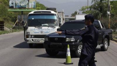 Un policía permite el paso a un vehículo que circula sin placa. Foto: Melvin Cubas.