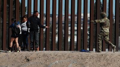 Integrantes de la Guardia Nacional de Estados Unidos impide el avance de un grupo de migrantes que intentan cruzar la frontera con México, en Ciudad Juárez.