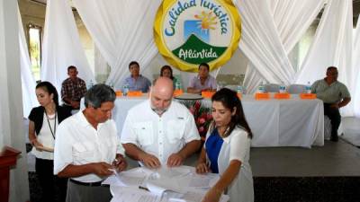 Ferdinand Florentino, director de la Cámara de Turismo de Tela; John Dupuis, director de la Cámara de Turismo de La Ceiba, y Lourdes Bados del proyecto Destino Atlántida en la firma.