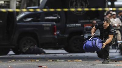 Miembros del escuadron antibombas de Brasil inspeccionan una maleta sospechosa en Río.