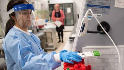 LAKE SUCCESS, NY - MARCH 11: A lab technician begins semi-automated testing for COVID-19 at Northwell Health Labs on March 11, 2020 in Lake Success, New York. An emergency use authorization by the FDA allows Northwell to move from manual testing to semi-automated. Andrew Theodorakis/Getty Images/AFP