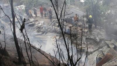 Bomberos y ciudadanos en un incendio ocurrido en la colonia Los Ángeles, al sureste de San Pedro Sula. Foto de archivo LA PRENSA.
