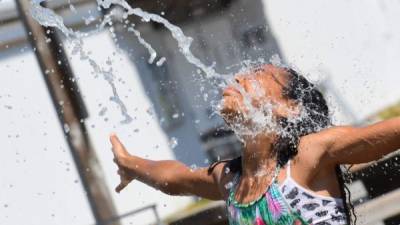 Los niños se refrescan en un parque acuático comunitario en un día caluroso en Richmond, Columbia Británica. Las escuelas y los centros de vacunación Covid-19 cerraron el lunes mientras que los centros comunitarios de enfriamiento se abrieron. La ola de calor sin precedentes rompió varios récords de temperatura.