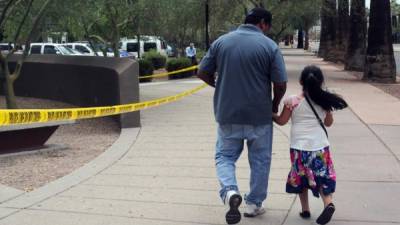 Un hombre camina junto a su hija tras salir de una cita en la Oficina de Control de Inmigración y Aduanas (ICE), desde donde supuestamente se transportará a los menores de 5 años liberados para reunificarlos con sus padres hoy, martes 10 de julio de 2018, en centro de Phoenix, Arizona (EE.UU.). EFE