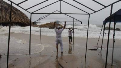 Pescadores intentan recobrar su punto de venta destrozado por fuertes olas. EFE/archivo
