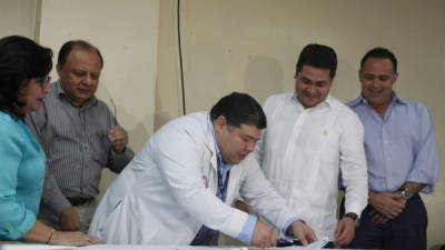 Juan Carlos Argueta, director del Mario Rivas, firma el acta de compromiso frente a autoridades de Salud, el Presidente de la República y el alcalde de San Pedro Sula.