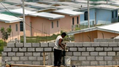 Un trabajador coloca cemento en la estructura de bloques de una urbanización en Bosques de Jucutuma.