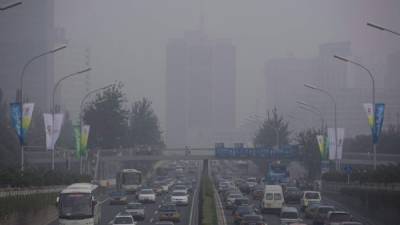 Cientos de vehículos se ven rodeados por una nube de intensa bruma en una autopista de Pekín (China). EFE/Archivo