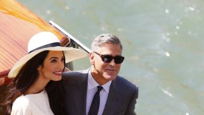 El actor George Clooney y su mujer, Amal Alamuddin, disfrutan de un paseo por las calles de Venecia de la mano este lunes, a su llegada al ayuntamiento de Venecia para hacer oficial su matrimonio. Ella, ya como mujer del actor, elige la pamela para su estilismo de Stella McCartney.